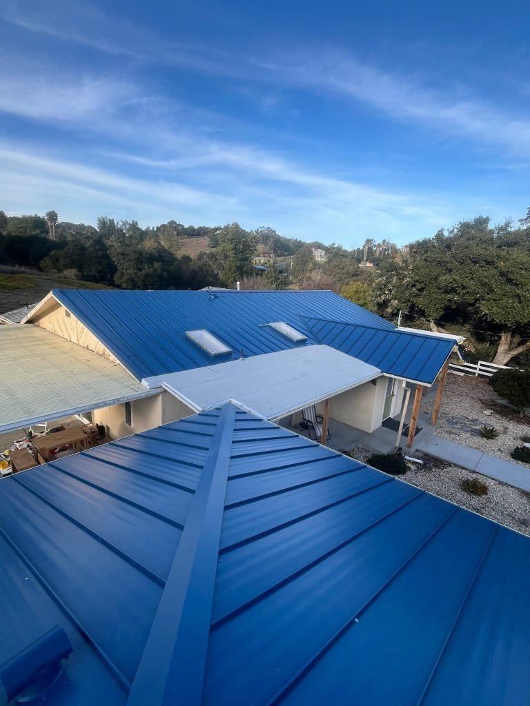 blue metal roof installation on a home shown as an example when answering "What is the best roofing material for California?"